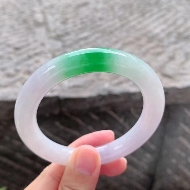 春彩翡翠手鐲圓條 玉質(zhì)細膩溫潤，粉紫底浪漫溫馨，一處陽綠楚楚動人，上手高貴華麗，無裂紋。 圈口：53.7/9.8/10mm 價格：小六一開
