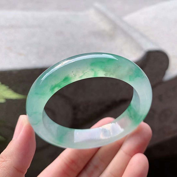 翡翠 【手鐲】高冰木那綠花正圈 【圈口】52.6/12.6/8.5mm 【價(jià)格】六位數(shù) 【編碼】0708052 【描述】老坑料，水汪汪的質(zhì)地，膠感濃郁，熒光四溢，整體木那雪花棉點(diǎn)開，綠花兒輕盈飄逸，完